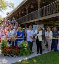 Joyful ribbon-cutting ceremony with diverse attendees celebrating a new establishment, showcasing community support and excitement.